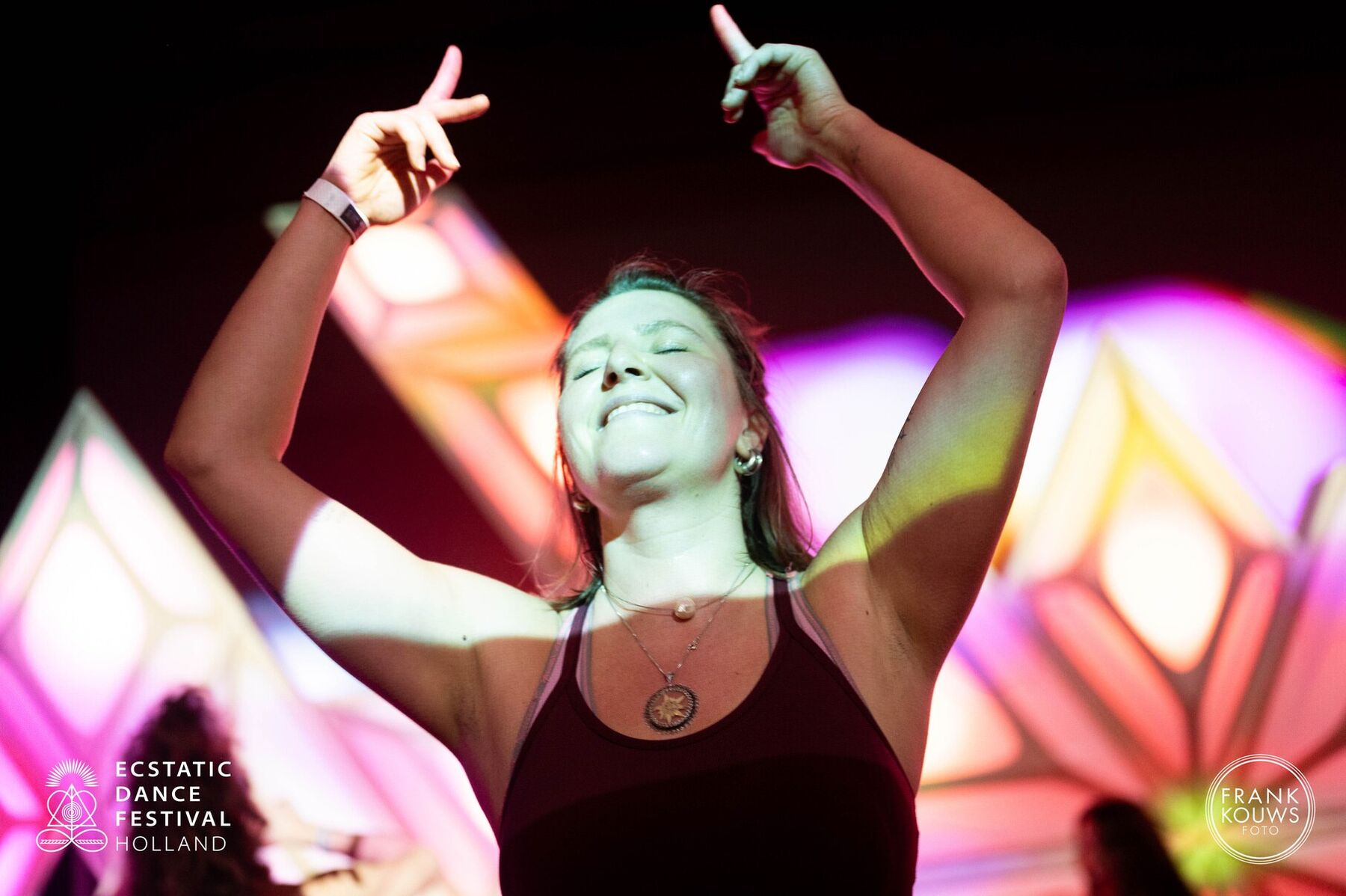 A dancer, arms raised, fully alive