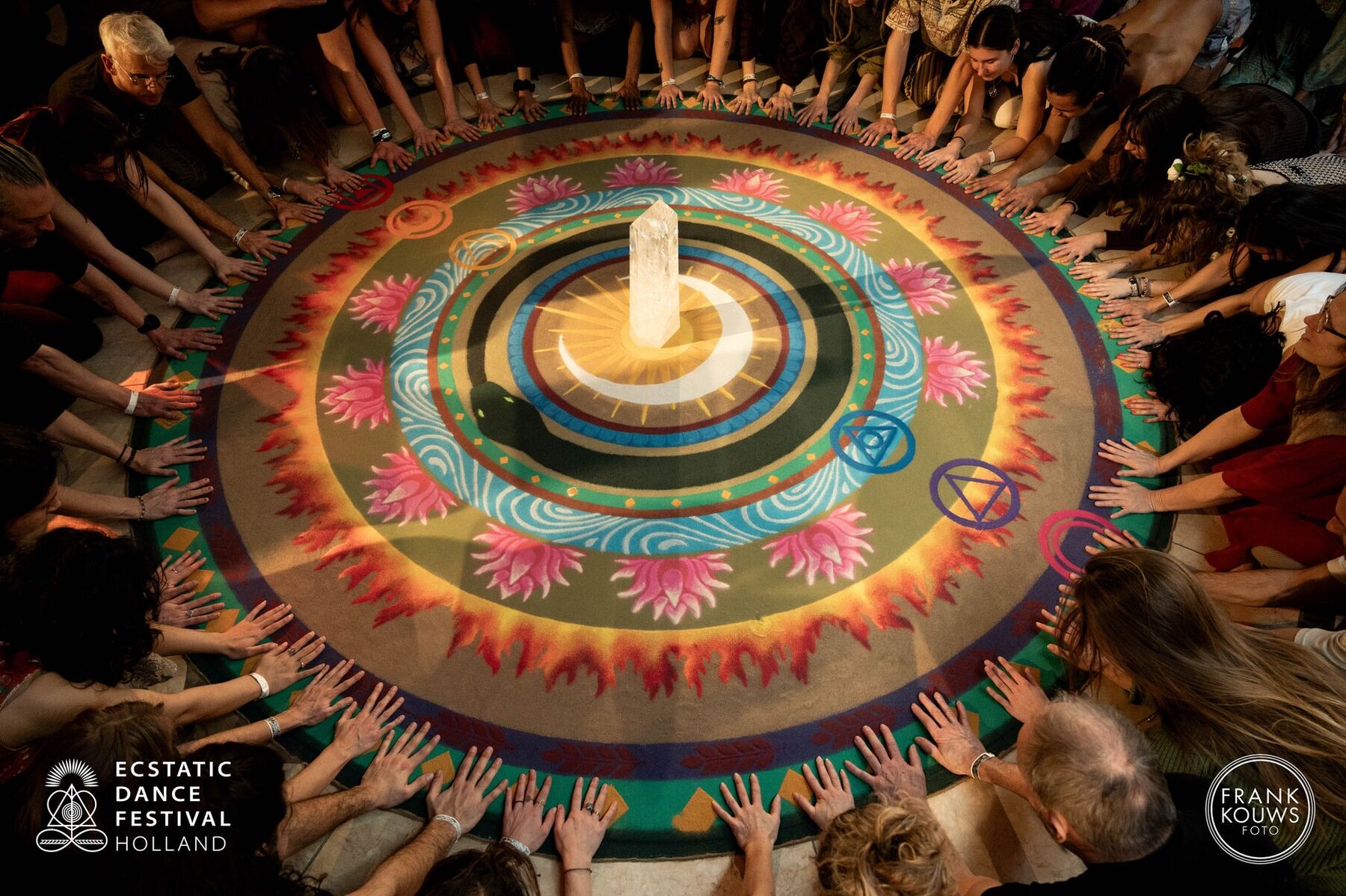 A circle of people around a mandala, seen from above